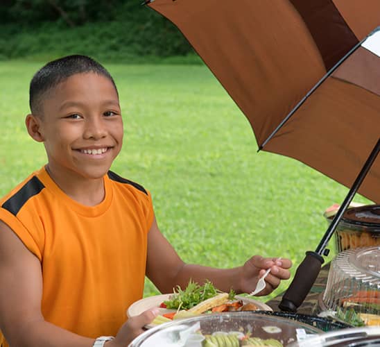Young boy sitting at a table with plant-based foods